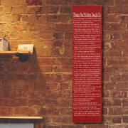 red wood sign with text against a brick wall