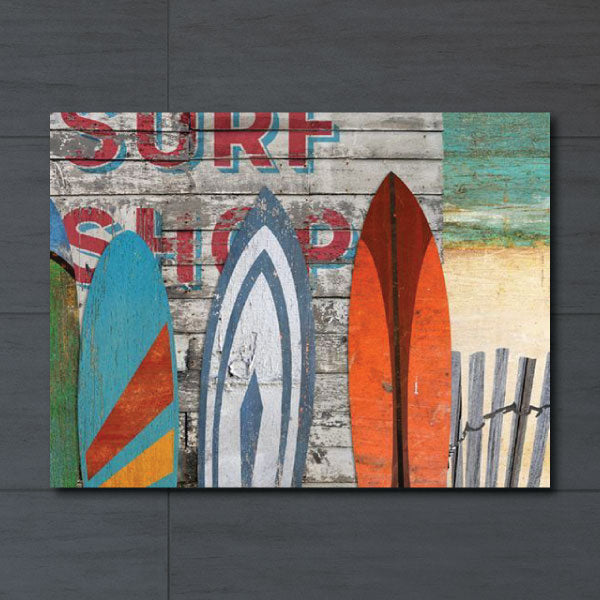 Wall art of surf boards leaning against the outside wall of a beach, surf shop