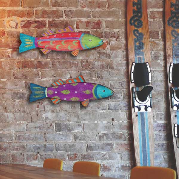 Colorful fish wall art with waterski against a brick wall