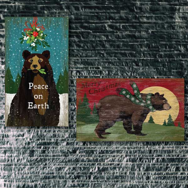 dark stone wall with two vintage wood signs for the holidays handing; both with images of bears