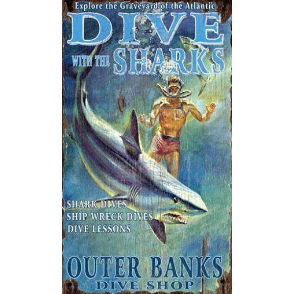 hand painted (?) image of man diving with a shark; ad for Outer Banks Dive Shop; distressed wood sign