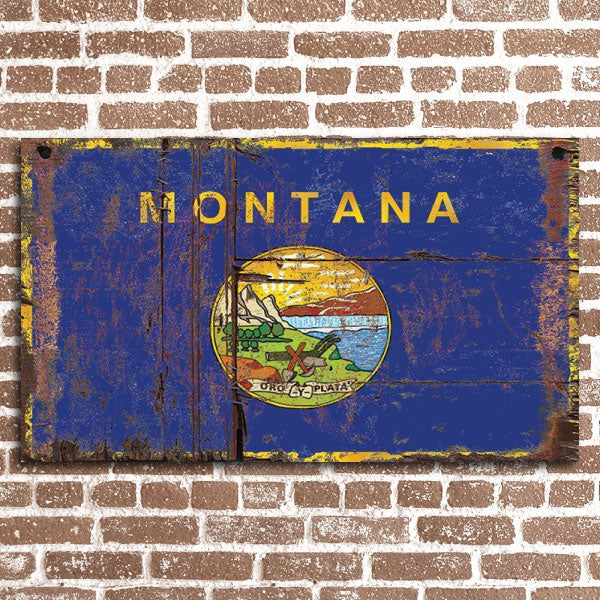 Distressed Montana flag printed on wood boards against a brick wall