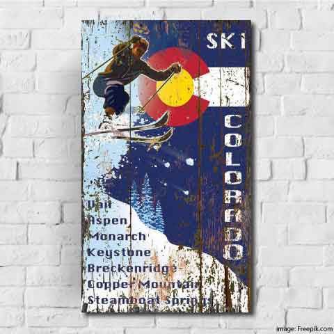 skier racing down the mountain with the Colorado state flat as the background; Ski Colorado; Vail, Aspen, Keystone, Breckenridge, Copper Mountain, Steamboat