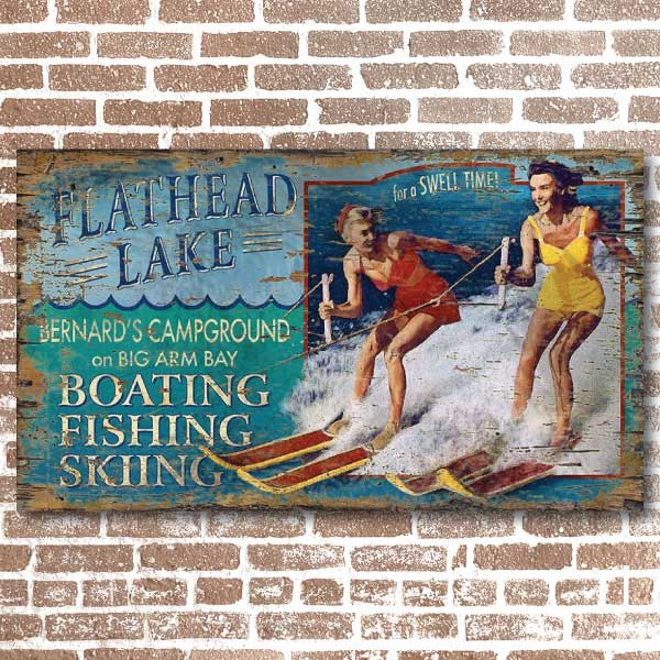 Old wood sign with retro ad for waterskiing on Flathead lake.