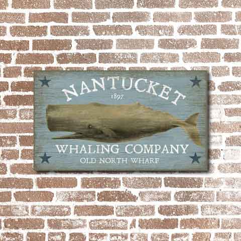 Weathered sign hung on brick wall. Old North Wharf. Image of a whale.