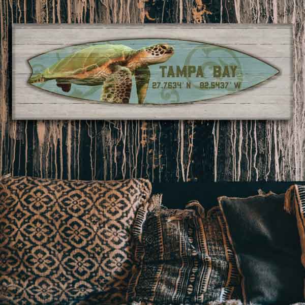 Image of surfboard with turtle on a wood boards hung on wood panel wall