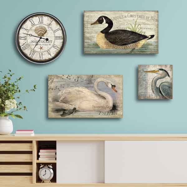 Collection of coastal vintage signs on aqua wall; goose, swan, haron and rustic clock